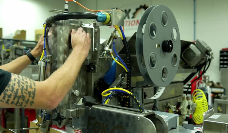 Operator adjusting a wicketed bagging machine during produce packaging process